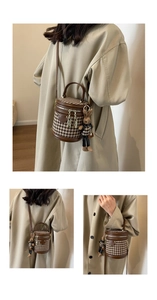 Detail of houndstooth bucket bag with leather trim and cute rabbit charm pendant