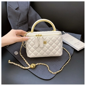 Dettaglio mini borsa a secchiello bianca trapuntata con manico d'oro e logo