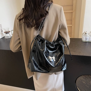 Grande borsa tote in pelle lucida nera con tracolla a catena e fiocco argento