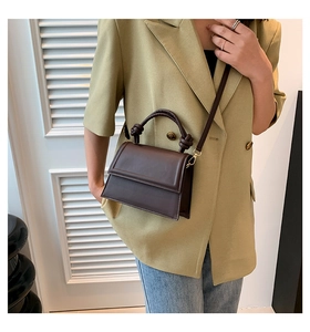 Dettaglio mini borsa marrone scuro con manico annodato e tracolla sottile rimovibile