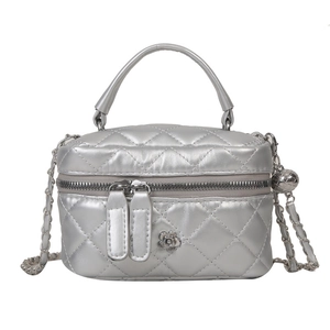 Sac boîte argenté métallisé avec matelassage, fermoir fleur et bandoulière chaîne sur fond blanc