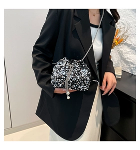 Dettaglio della borsa a secchiello con paillettes argento, catena e pendente con perla