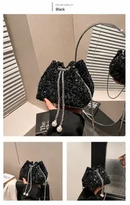 Dettaglio borsa a secchiello nera con paillettes, catena argento e ciondolo di perle