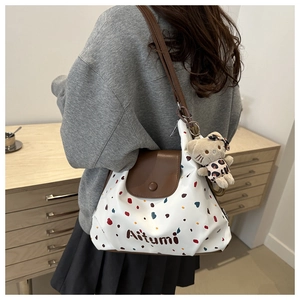 Borsa tote in pelle con pois colorati e patta marrone mostrata in uno stile elegante