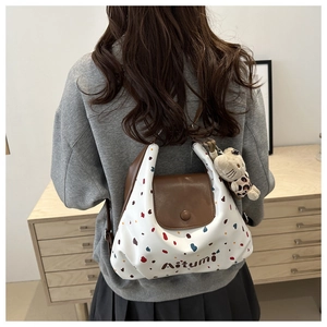 Vista posteriore di una borsa tote a pois con un simpatico ciondolo a forma di gatto per outfit