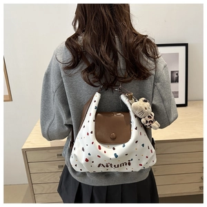 Borsa tote a pois con ciondolo a orsetto e cinturini in pelle marrone indossata da modella