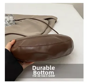 Detailed close-up of the wear-resistant bottom and stitching on a dark brown leather bag