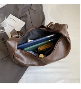 Interior storage space of the dark brown PU hobo bag with daily items inside