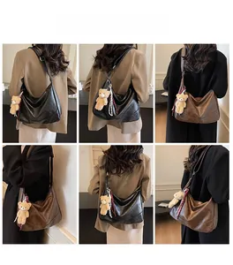 Detail view of large PU leather hobo bags in black and brown with bear charms