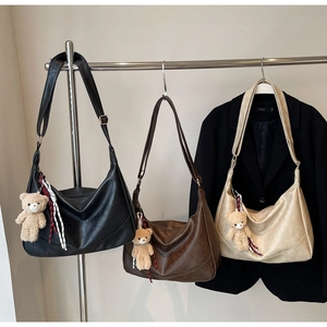 Three minimalist soft PU leather hobo bags in black, brown, and beige with cute bear charms