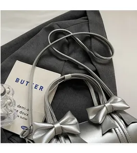 Macro detail of silver ballet-style cylinder bag featuring elegant double bow design