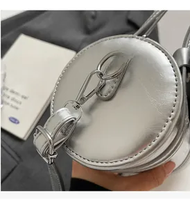 Detail of silver cylindrical handbag featuring premium metallic texture and glossy hardware