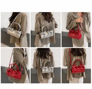 Chic ballet-style cylinder crossbody bag with bow detail and glossy metallic finish