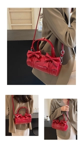 Three-way view of red cylindrical bow bag in shiny patent leather with silver hardware