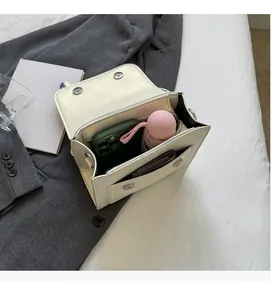 Interior view showing the storage capacity of the cream crossbody square bag