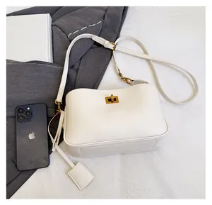Size comparison of cream lychee leather handbag next to a smartphone for scale