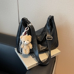 Minimalist black PU leather hobo shoulder bag with cute plush bear charm and wide strap
