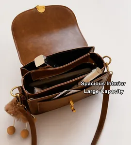 Detail view of brown vintage crossbody bag interior with large capacity and zip pocket