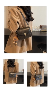 Model wearing a black vintage crossbody bag with gold buckle and brown bear charm