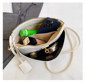 Internal view of a white leather crossbody bag showing spacious storage for daily items