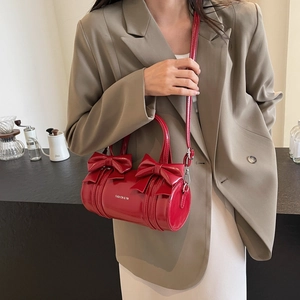 Elegant red shiny patent leather cylinder shoulder bag with sweet bow decorations