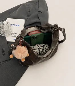 Top view of large brown tote bag interior with pink wallet and green phone inside