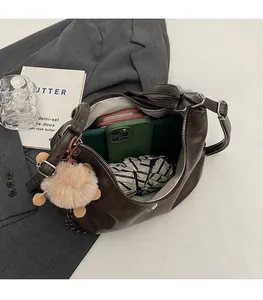 Top view of large brown tote bag interior with pink wallet and green phone inside