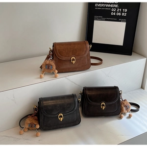 Detailed view of leather flap bags in black and brown with golden metal locks
