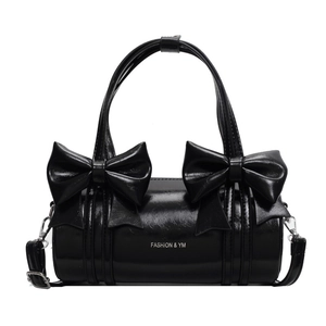Elegant black cylinder crossbody bag with large decorative bows and silver hardware
