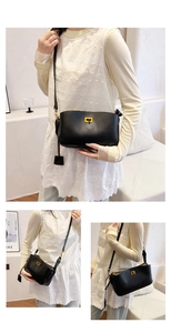 Detailed view of the black leather crossbody bag with a gold buckle on the model