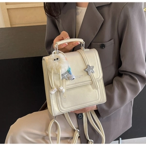 Detail of off-white PU leather backpack with star accents and fluffy monster charm