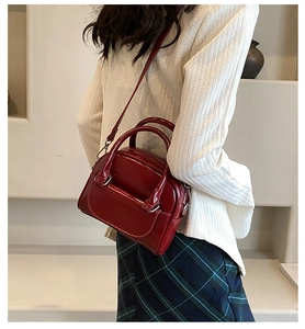 Close-up of red patent leather mini handbag with silver hardware on a shoulder strap