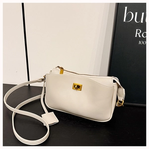 Detail view of the sleek metal twist lock and white faux leather texture on the bag