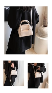 Detail of minimalist cream patent leather handbag with adjustable strap and silver hardware