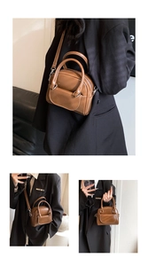 Detail of a brown patent leather shoulder bag with top handles and adjustable strap