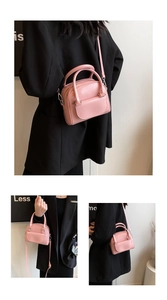 Detail of pink mini patent leather crossbody bag with top handles and adjustable strap