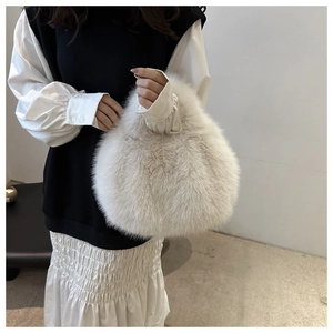 Detail shot of beige plush faux fur handbag showing soft texture and fluffy top handle