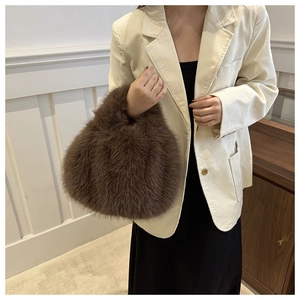 Close-up of a brown plush faux fur tote bag worn with a beige corduroy blazer