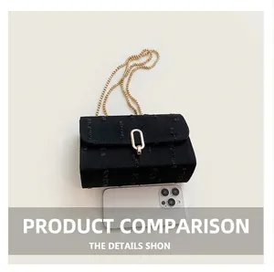 Detail of compact black denim chain bag with gold buckle next to a smartphone