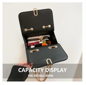 Interior view showing the capacity of a black leather flap bag with gold chain strap