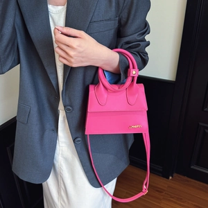 Fashionable bright pink mini handbag with circular top handle and adjustable shoulder strap