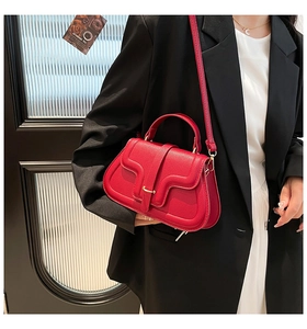 Detailansicht rote Handtasche aus Kieselleder mit Wellennähten und Gold-Metallschnalle