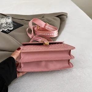 Detailed macro view of the durable double-layer folded base on a pink textured crossbody bag