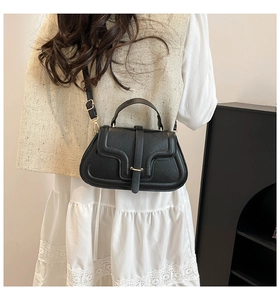 Detail der schwarzen Tasche aus Leder mit Lychee-Narbung und goldenen Beschlägen
