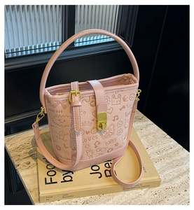 Detail of pink bucket bag with cartoon graffiti art and metal buckle on art book