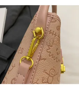 Detail of pink embossed leather bucket bag featuring gold hardware and cartoon print