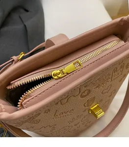 Close-up of pink PU leather bag featuring cat and heart embossing with gold metal zipper