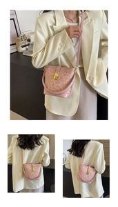 Detail view of pink bucket bag featuring graffiti heart prints and gold metal clasp