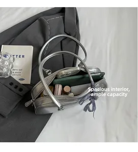 Macro view of silver metallic bag showing large interior capacity with a scarf detail