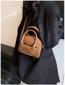Detail of vintage brown patent leather handbag with silver hardware and smooth finish